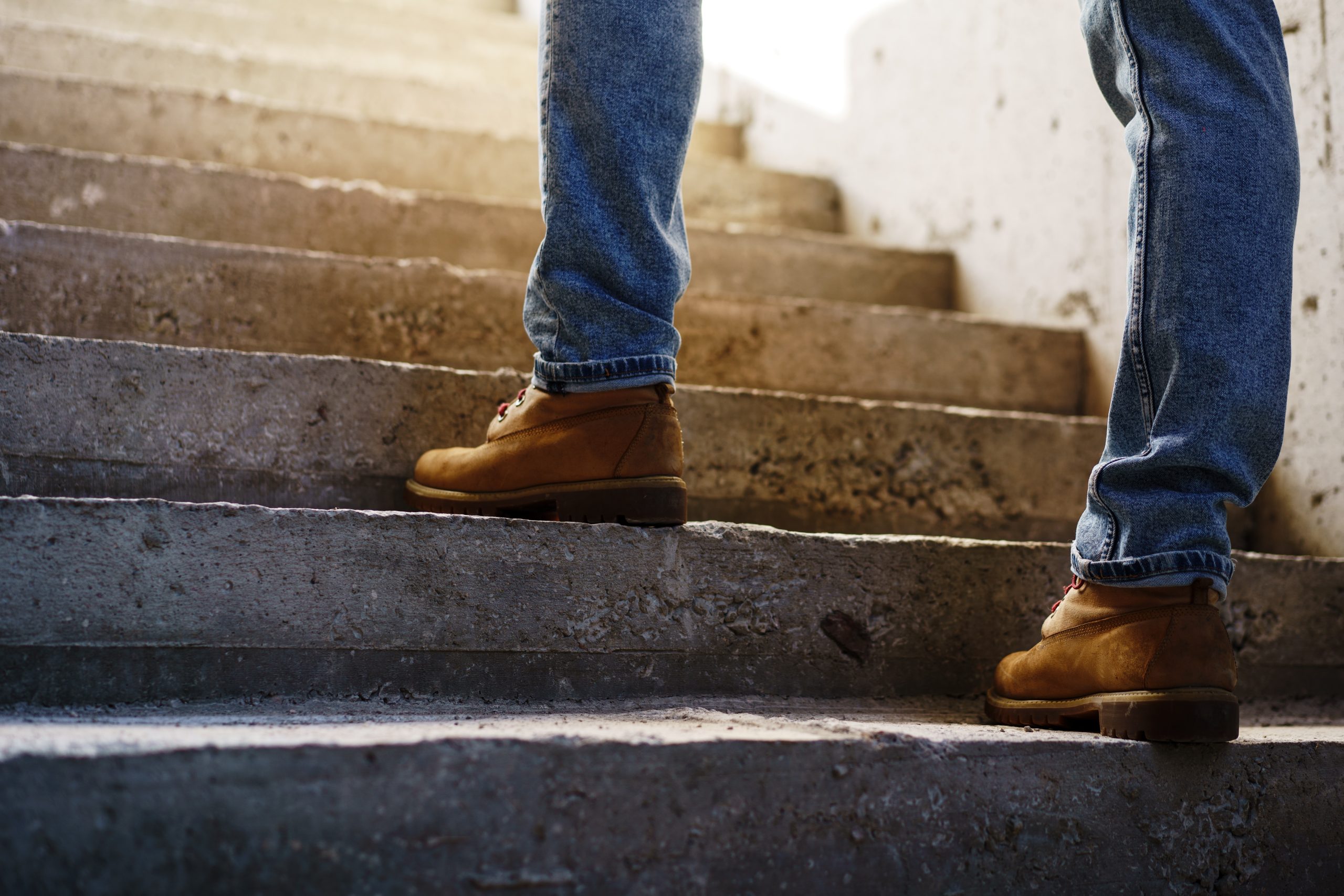 Close up photo of man walking up on concrete staircase